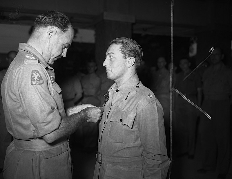 Adjudant-generaal kolonel C.H.J.F. van Houten reikt het officierkruis in de Orde van Oranje-Nassau uit aan majoor H.C. Druce.